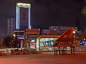 本站B出入口无障碍电梯出口一侧,后方为八卦街旧址及中富国际酒店